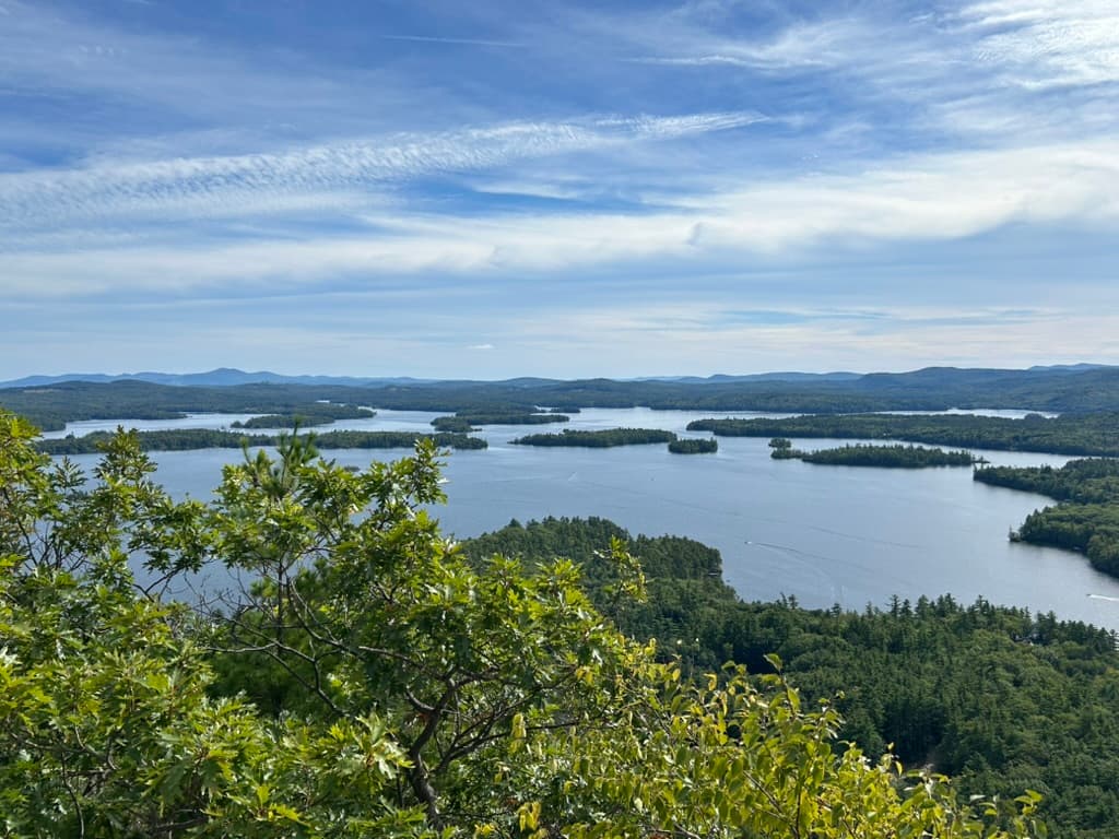 A lake dotted with wooded islands, seen from a summit